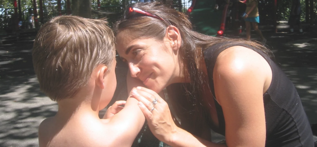 Mother comforting and speaking to her child outside