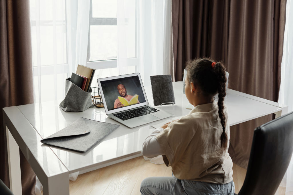 Little girl sitting at a desk taking an online class