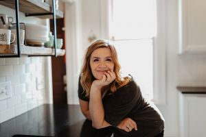 Amber Brandt poses in her kitchen with her chin resting in her palm