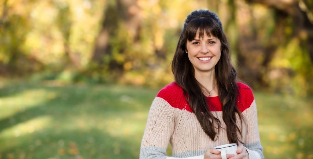 Kristin Vorce poses outside holding a coffee mug