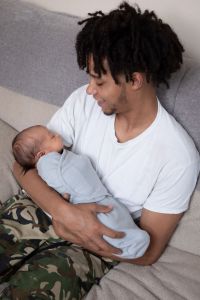 New father holds his swaddled infant