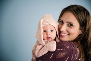 Sarah Lewis holding a baby dressed in a knitted bunny outfit