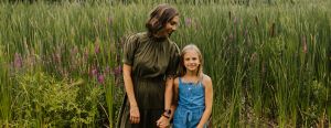 Alyssa Veneklase holds her daughter's hand in front of a field