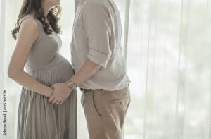 Pregnant woman with her spouse standing together while holding the child in her womb together