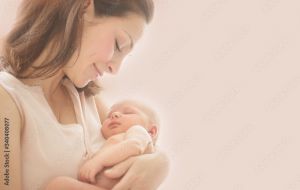 Mother admiring and holding her sleeping infant