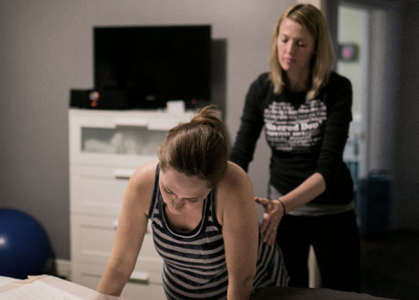 Birth doula, Kristin Revere, comforting a laboring mother in a private birthing room