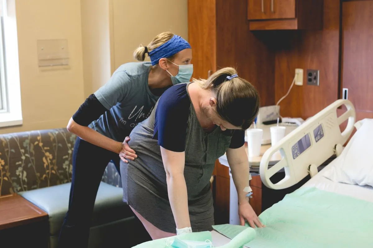 Birth doula, Kristin Revere, of Gold Coast Doulas assists a laboring mother in a hospital room