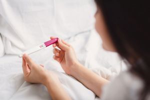 Woman holding a positive pregnancy test