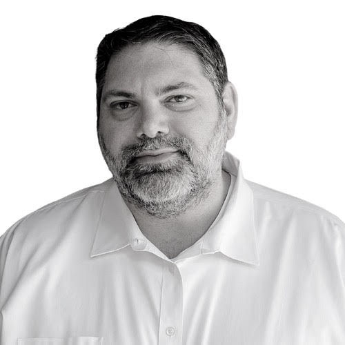 Black and White of Dr. Berlin wearing a white button down shirt against a white background