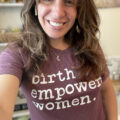 Angela Mancini taking a selfie wearing a "birth empowers women" shirt