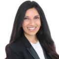 Dr. Payal Adhikari posing against a white background wearing a white blouse and black blazer