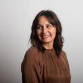 Lisa Newhouse of Gold Coast Doulas wearing a brown blouse with a purple background headshot