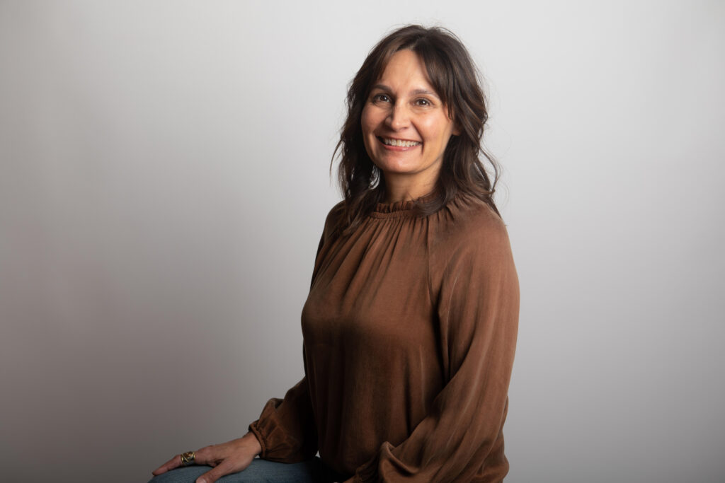 Lisa Newhouse of Gold Coast Doulas wearing a brown blouse with a purple background