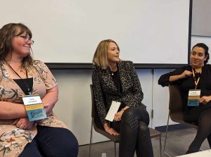 3 women sitting on stage during DoulaCon panel discussion on stage