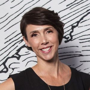 Alyssa Veneklese smiling for photo wearing a black top in front of a black and white background